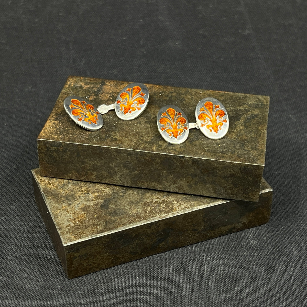 A pair of cufflinks with orange enamel