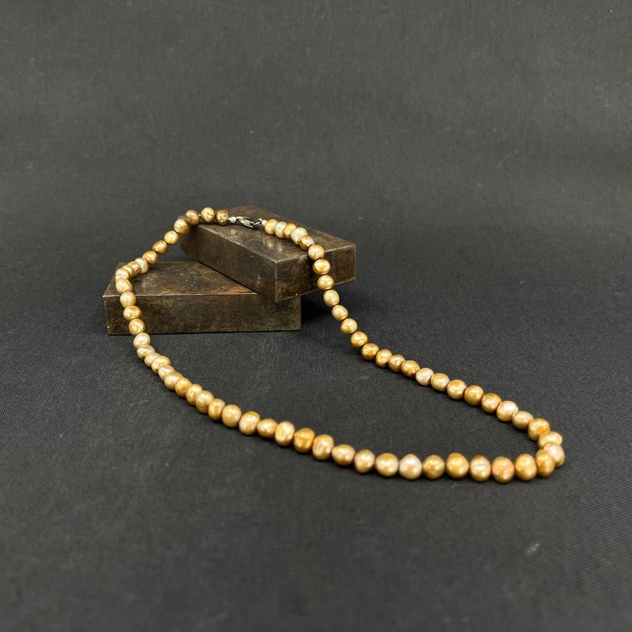 Gold-tone pearl necklace with a silver clasp
