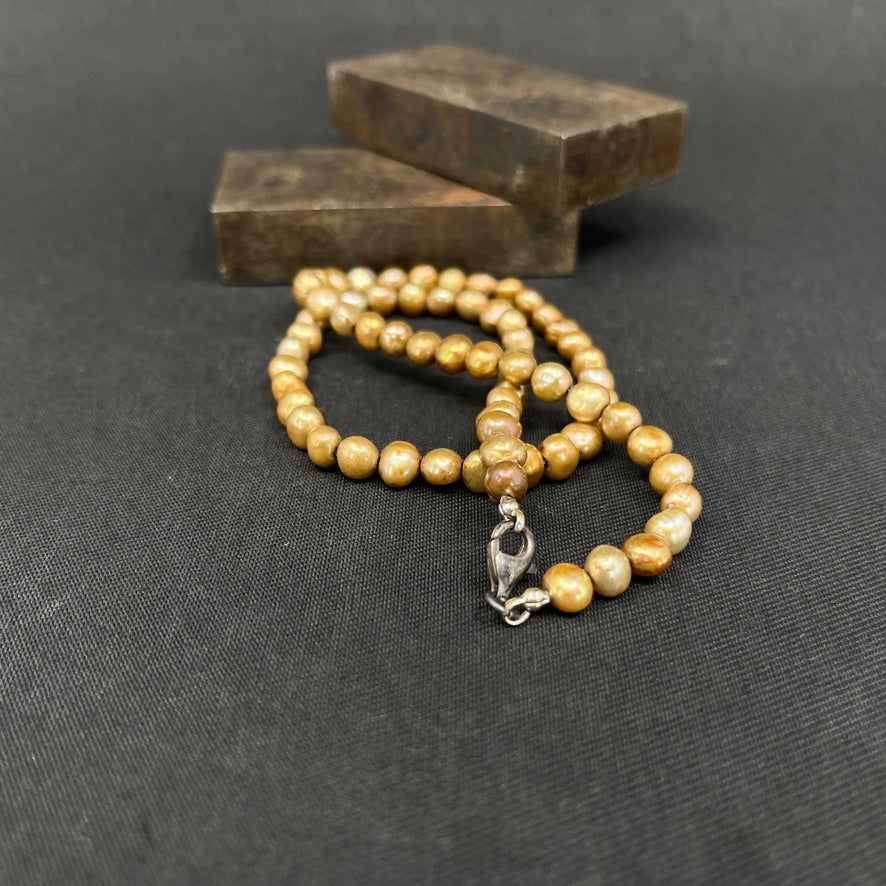 Gold-tone pearl necklace with a silver clasp