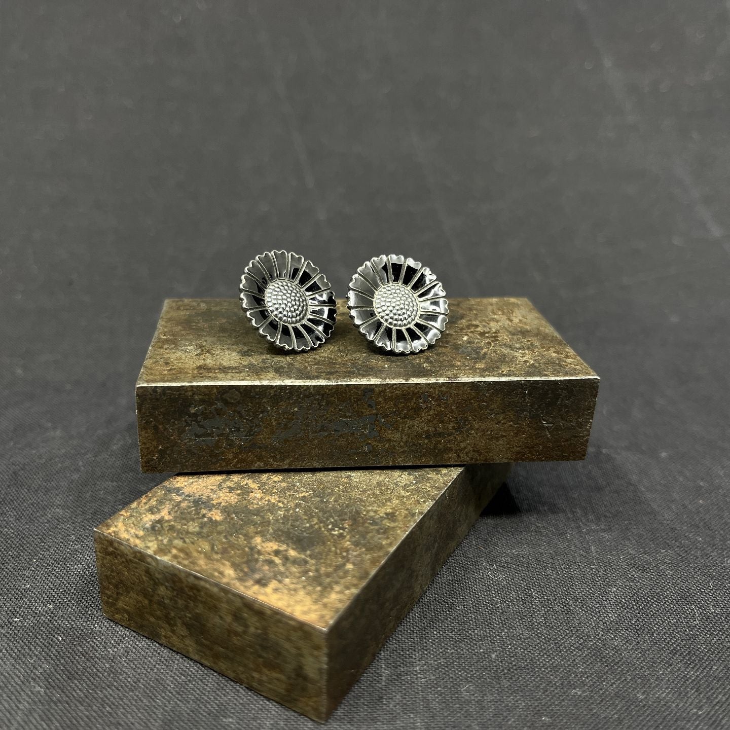 A pair of black daisy earrings