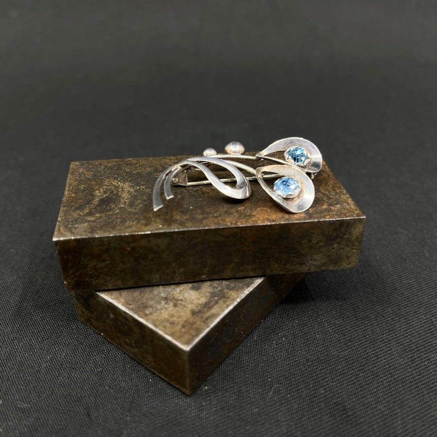 Moderne broche med lyseblå glitterstene