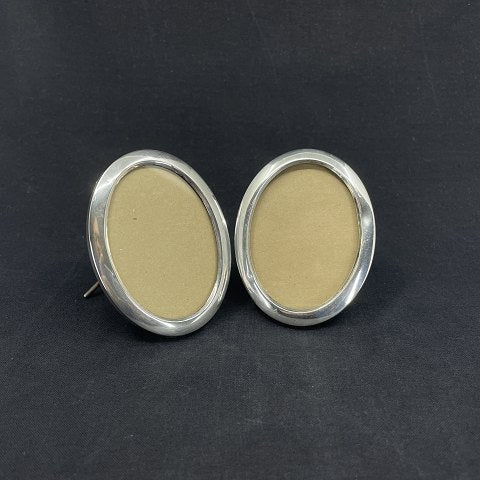 A pair of oval picture frames in silver