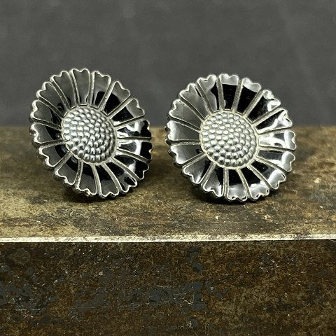 A pair of black daisy earrings