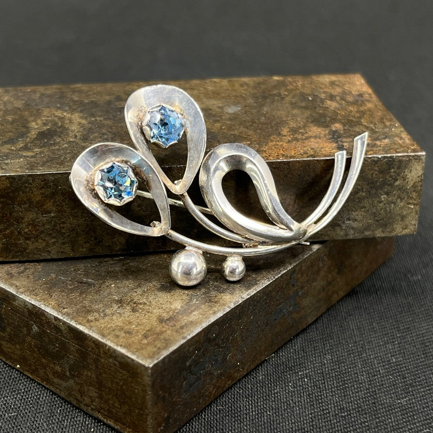 Moderne broche med lyseblå glitterstene