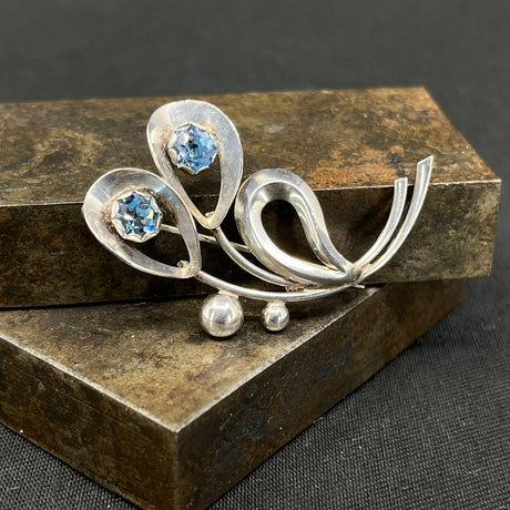 Moderne broche med lyseblå glitterstene