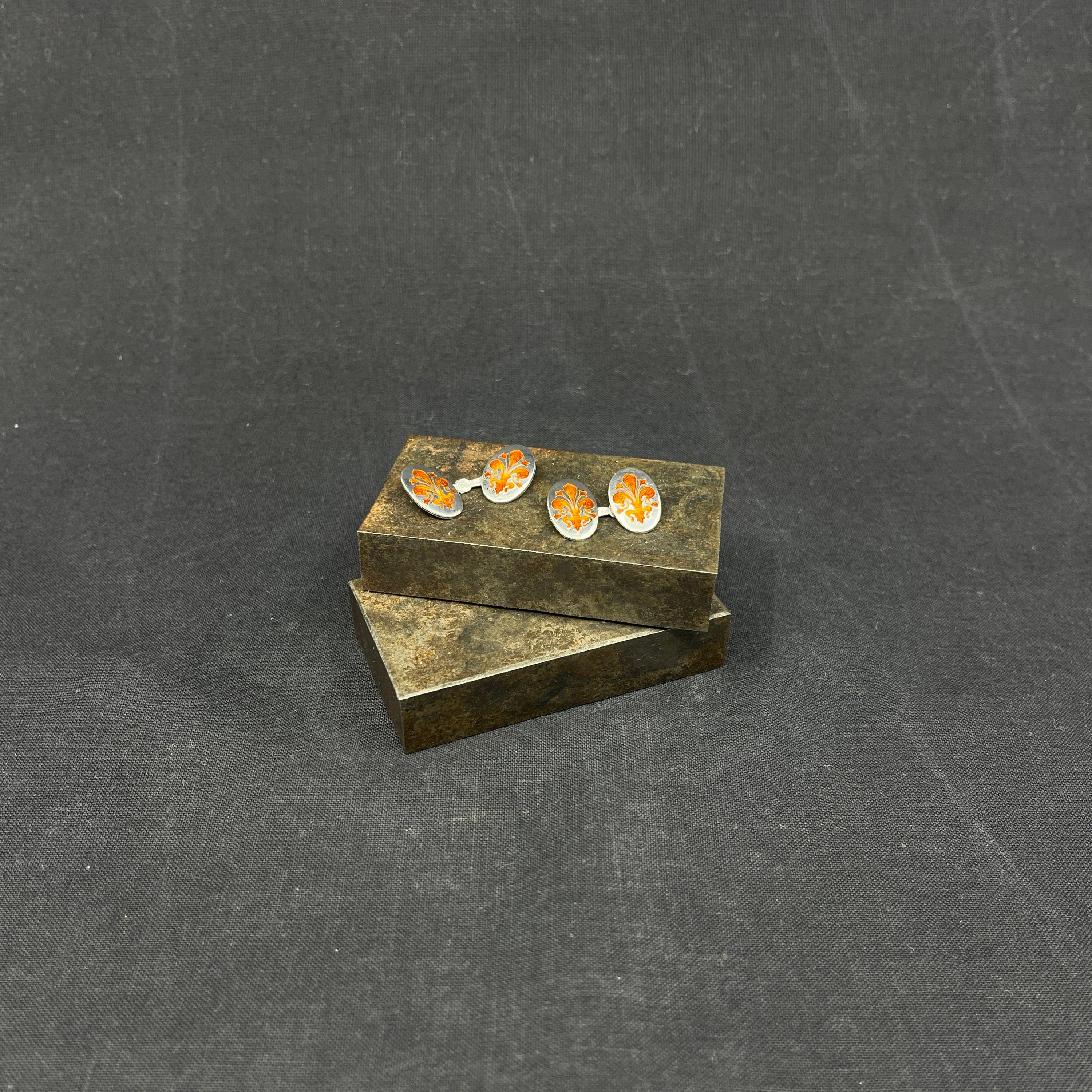 A pair of cufflinks with orange enamel