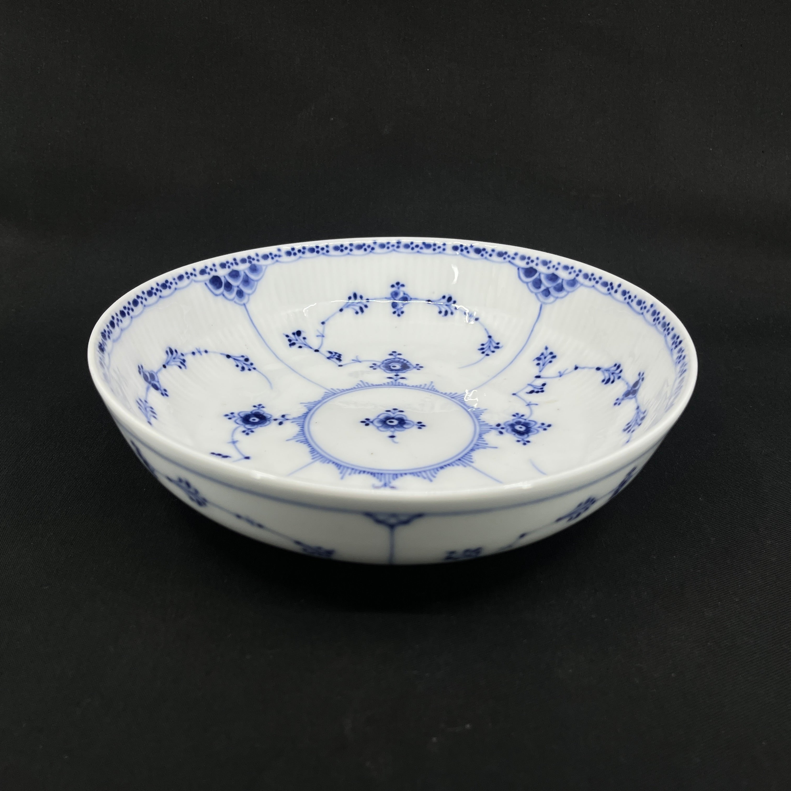 Blaue, geriffelte Kartoffelschale mit halber Spitze