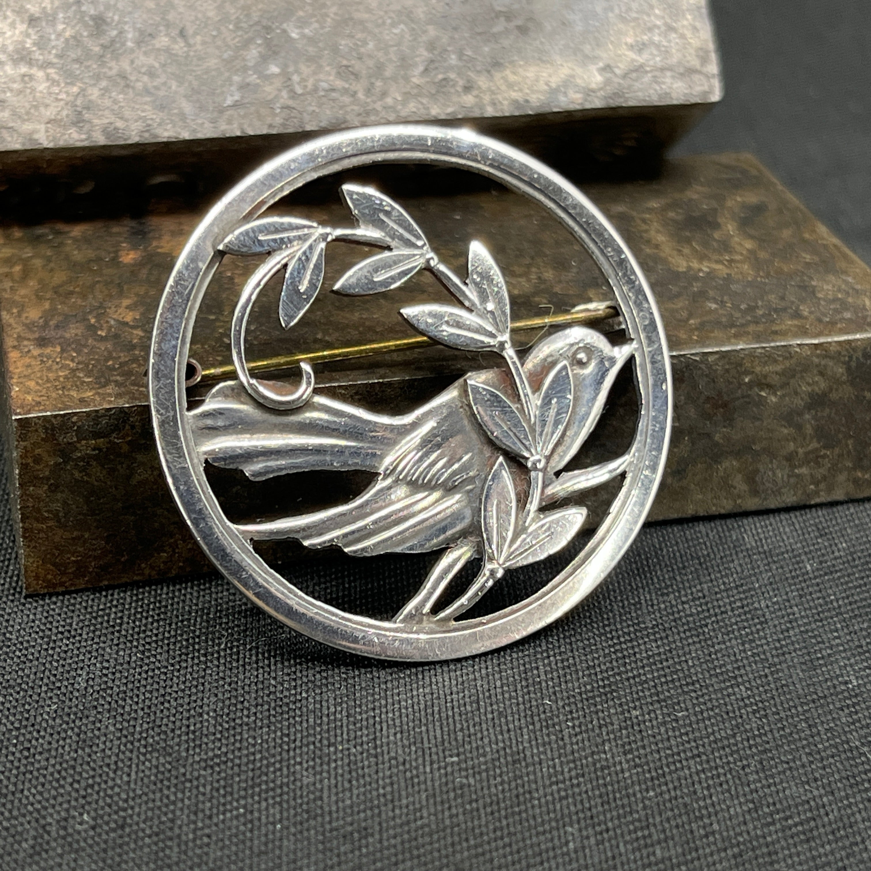 Broche i sølv med fugl