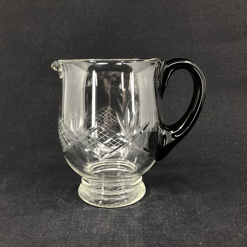 Fine jug in crystal glass with black handle
